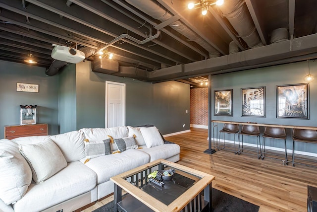 living room featuring wood-type flooring and brick wall