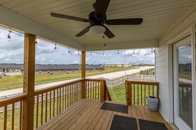 wooden deck with ceiling fan and a yard