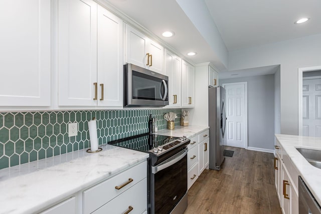 kitchen with dark wood-type flooring, tasteful backsplash, light stone counters, white cabinets, and appliances with stainless steel finishes