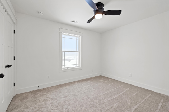 carpeted spare room featuring ceiling fan