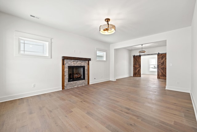 unfurnished living room with hardwood / wood-style floors and a barn door