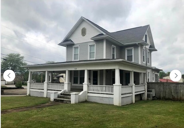 view of front facade featuring a porch, central AC, and a front yard