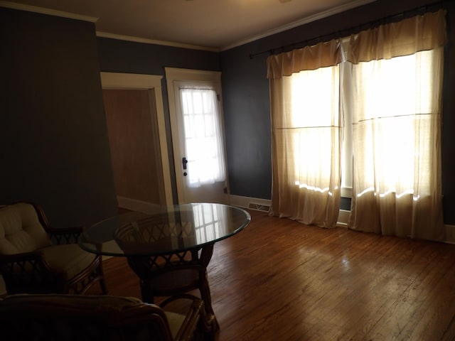 dining room with crown molding, plenty of natural light, and wood-type flooring