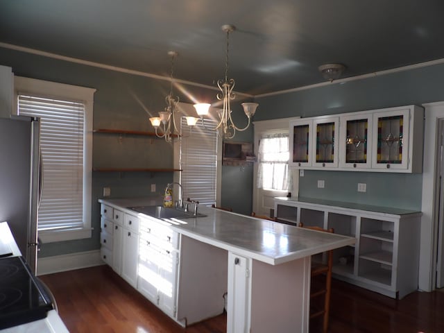 kitchen with white cabinetry, dark hardwood / wood-style flooring, an inviting chandelier, sink, and stainless steel refrigerator