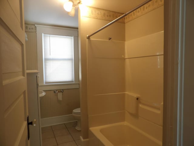 bathroom with toilet, tile patterned flooring, and bathtub / shower combination