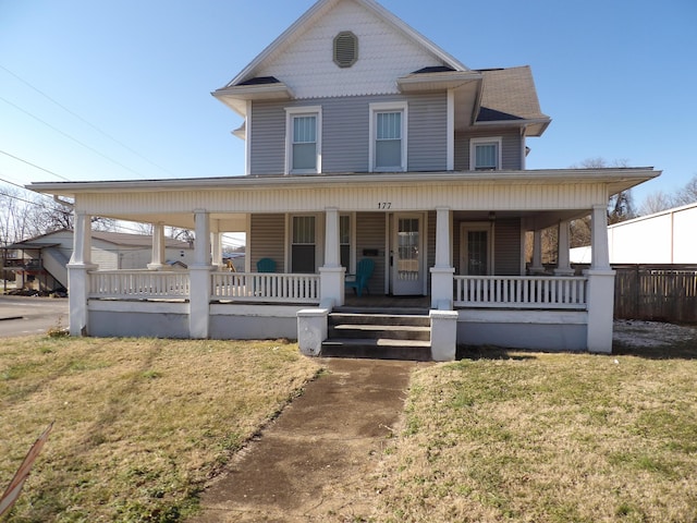 victorian-style house with a porch and a front lawn