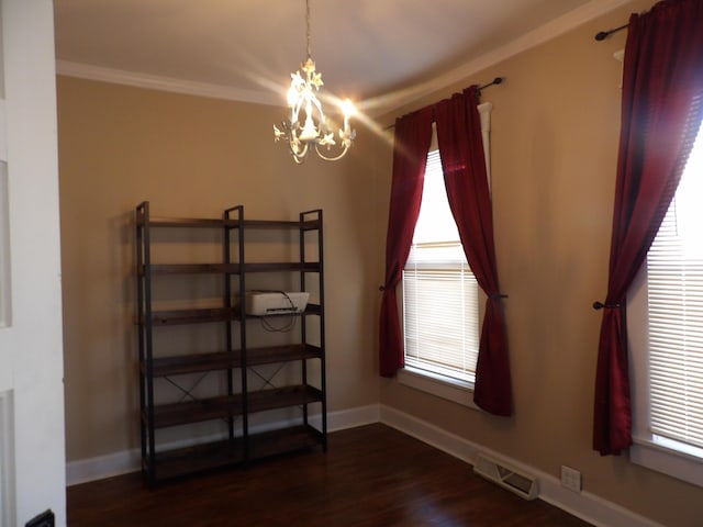 unfurnished room featuring an inviting chandelier, dark hardwood / wood-style flooring, and crown molding