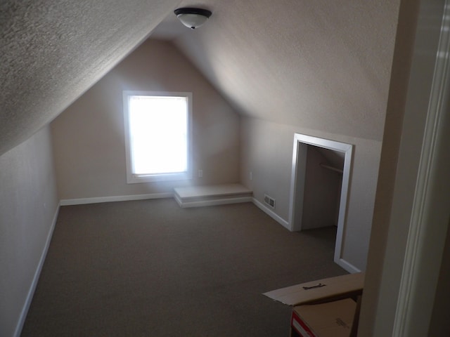 bonus room featuring vaulted ceiling and a textured ceiling