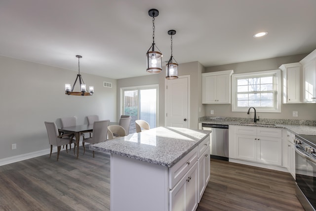 kitchen with white cabinets, a kitchen island, sink, and appliances with stainless steel finishes