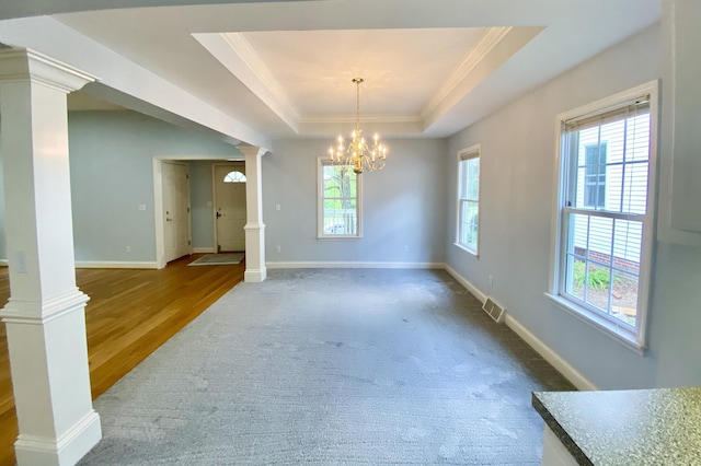 dining room with hardwood / wood-style floors, a notable chandelier, ornate columns, and a tray ceiling