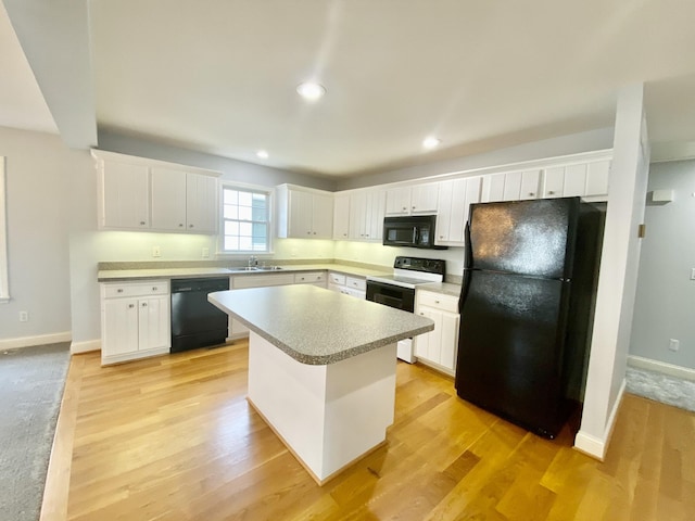 kitchen with white cabinetry, a kitchen island, and black appliances