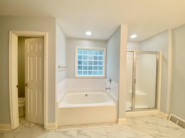 bathroom featuring toilet and plus walk in shower