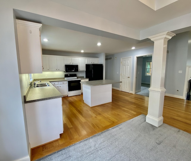 kitchen featuring sink, a kitchen island, light carpet, white cabinets, and black appliances