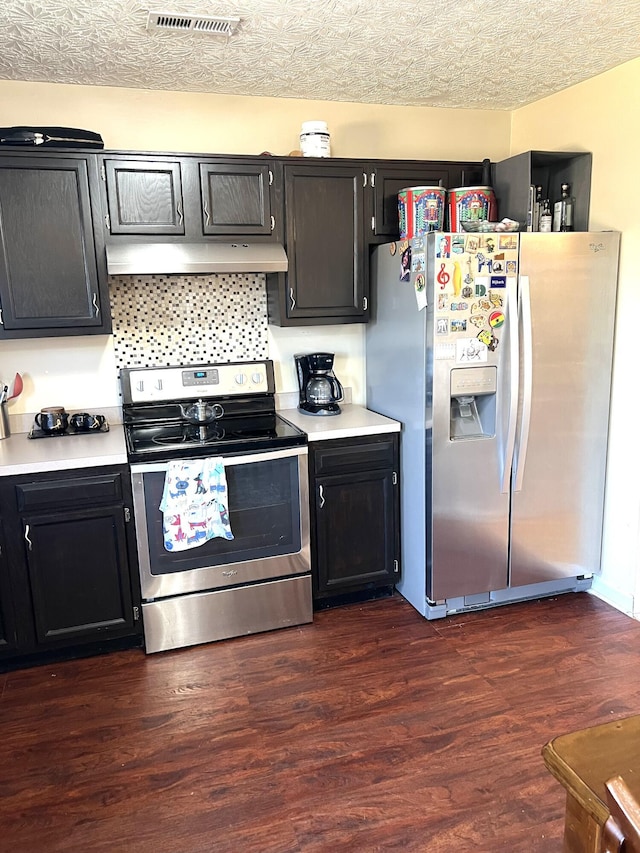 kitchen featuring appliances with stainless steel finishes, a textured ceiling, and dark hardwood / wood-style floors