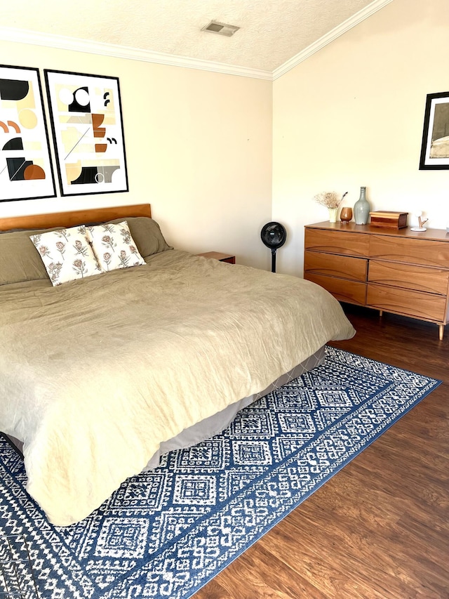 bedroom featuring crown molding, hardwood / wood-style floors, and a textured ceiling