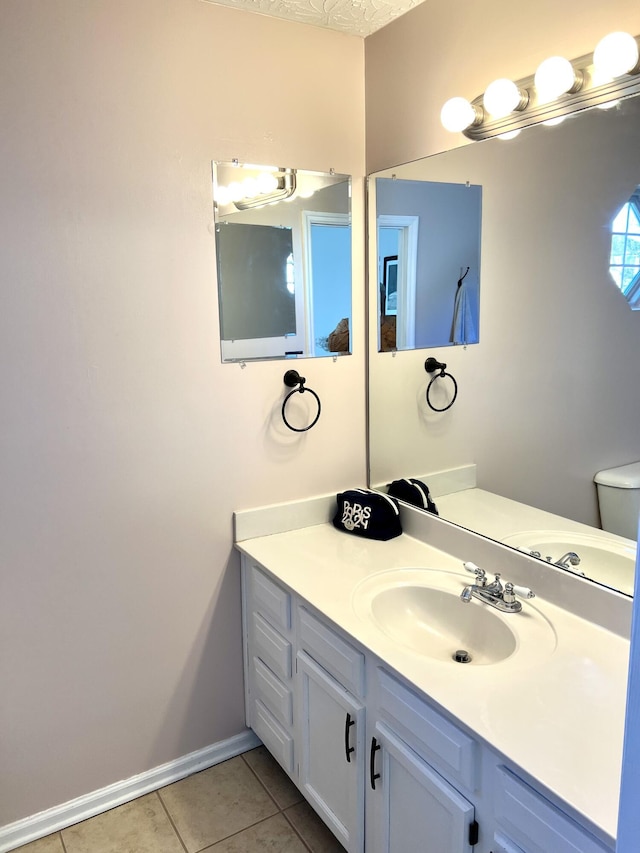 bathroom featuring tile patterned floors, vanity, and toilet