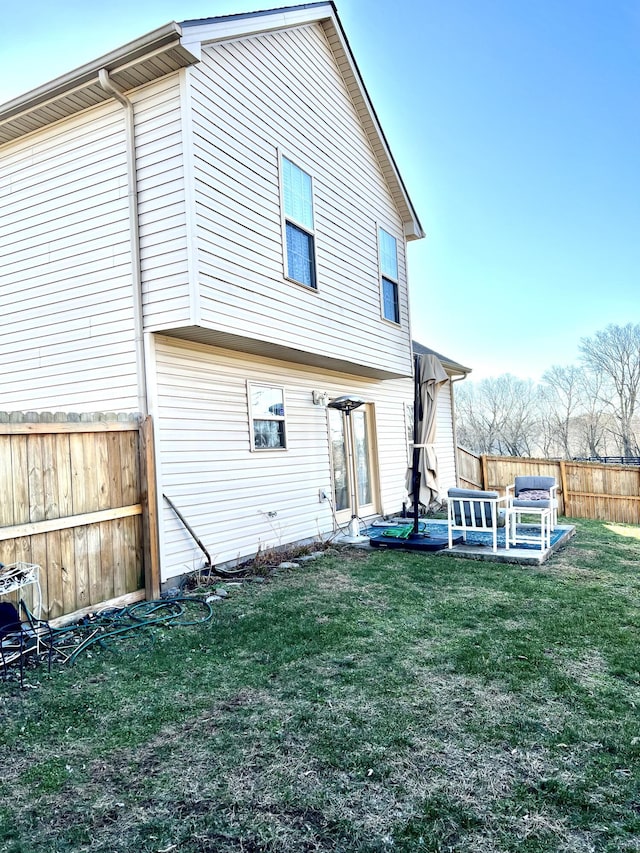 back of house with a patio area and a yard