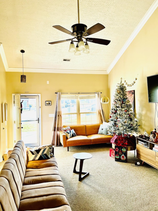 living room featuring ceiling fan, crown molding, carpet floors, and a textured ceiling