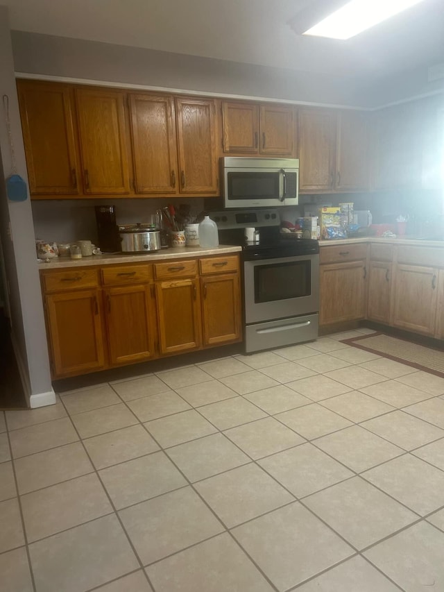 kitchen with light tile patterned floors and stainless steel appliances