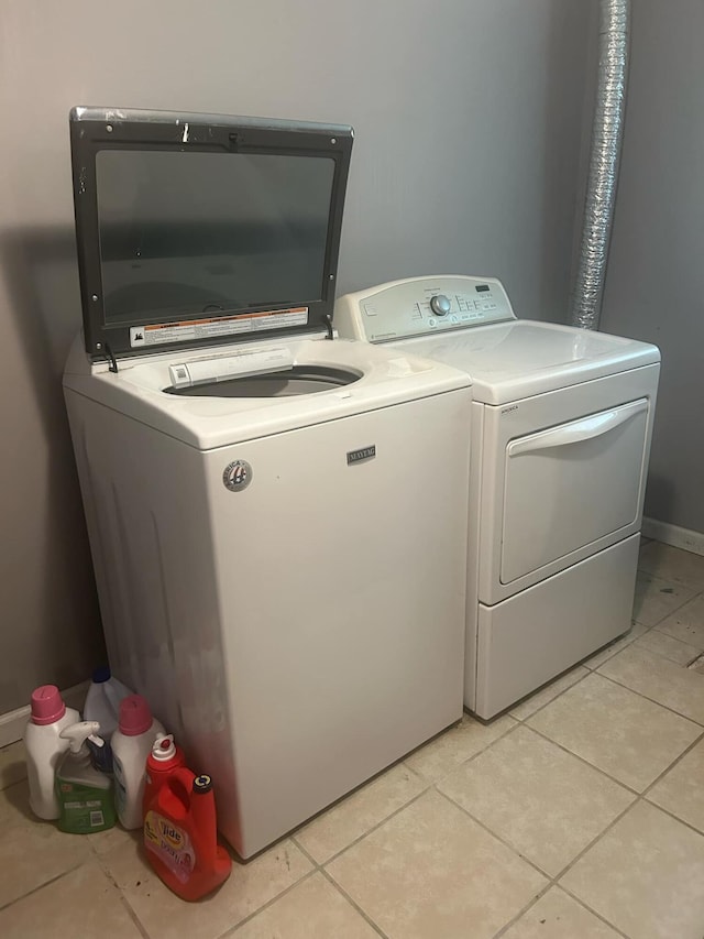 laundry area featuring separate washer and dryer and light tile patterned floors