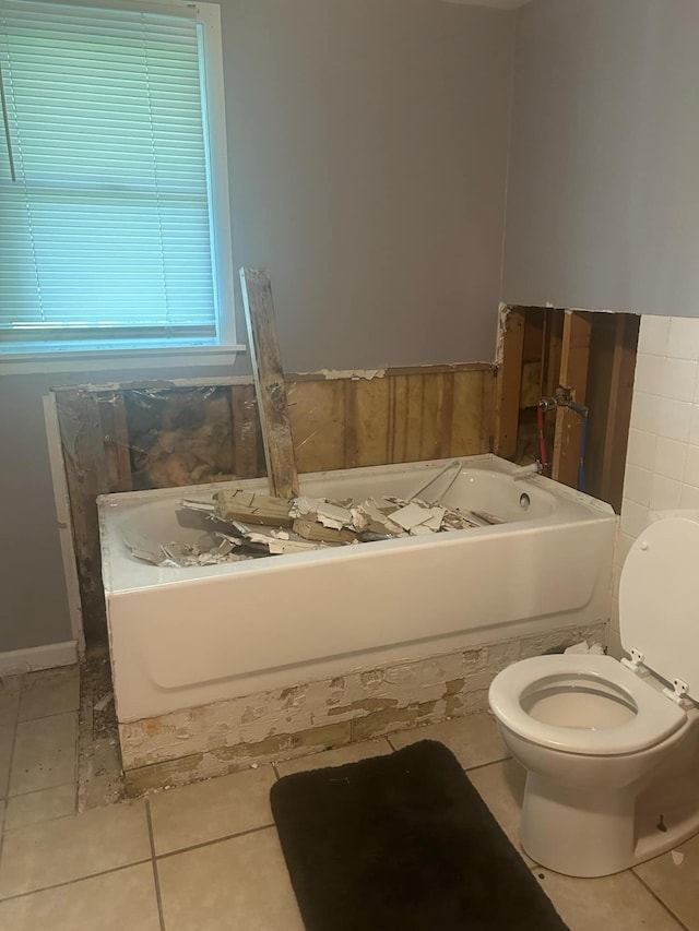 bathroom with tile patterned flooring, a bathtub, and toilet