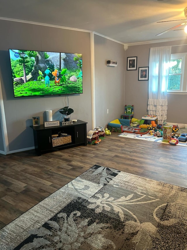 rec room featuring dark wood-type flooring, ceiling fan, and crown molding