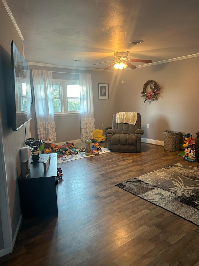 interior space with ceiling fan, ornamental molding, and dark wood-type flooring