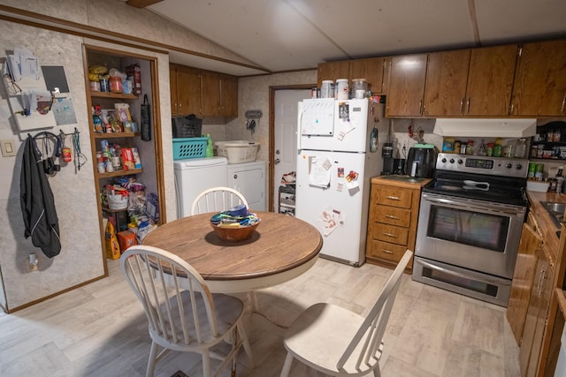 kitchen featuring vaulted ceiling, white refrigerator, washing machine and dryer, light hardwood / wood-style floors, and stainless steel electric range