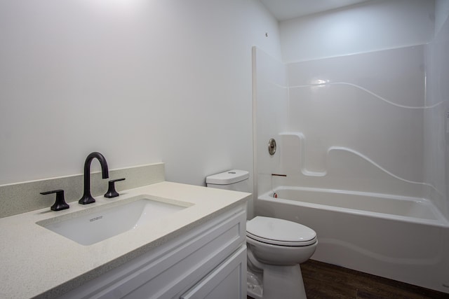 full bathroom featuring hardwood / wood-style floors, vanity, toilet, and  shower combination