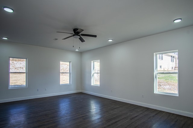 unfurnished room featuring a wealth of natural light, ceiling fan, and dark hardwood / wood-style floors