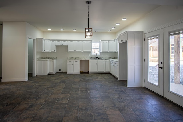 kitchen featuring white cabinets, sink, hanging light fixtures, and french doors