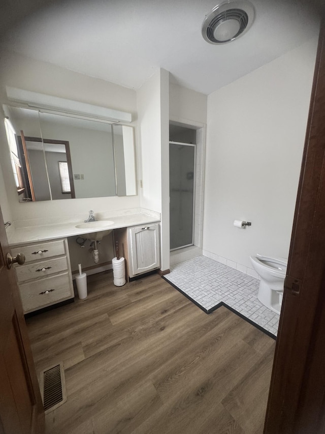 bathroom featuring hardwood / wood-style floors, vanity, toilet, and an enclosed shower