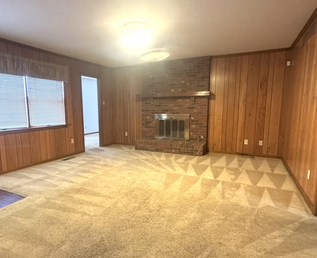 unfurnished living room featuring wood walls, a fireplace, and light colored carpet