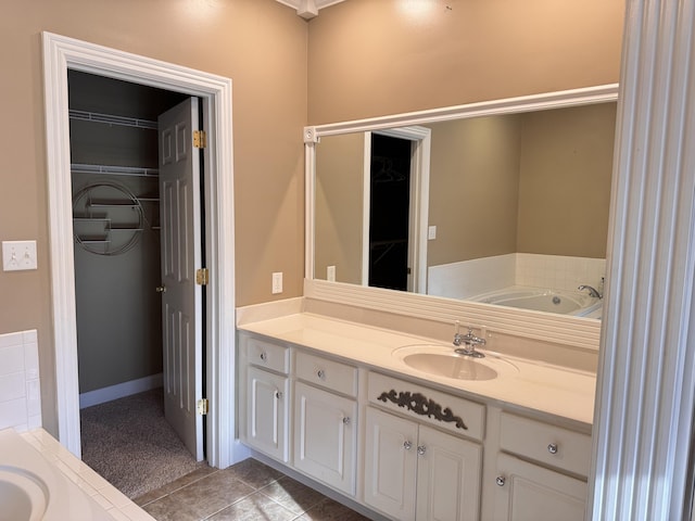 bathroom featuring a tub to relax in, tile patterned flooring, and vanity