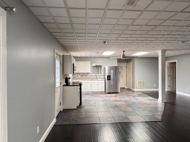 kitchen with decorative backsplash, stainless steel refrigerator with ice dispenser, stove, ceiling fan, and white cabinets