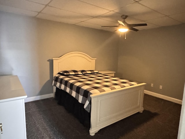 carpeted bedroom featuring a drop ceiling and ceiling fan