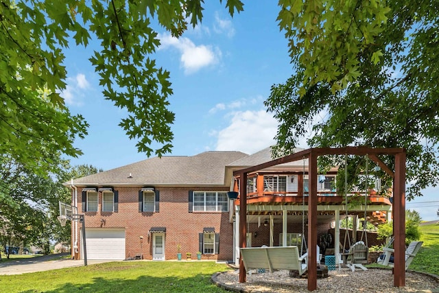 rear view of house featuring a lawn, a wooden deck, and a garage