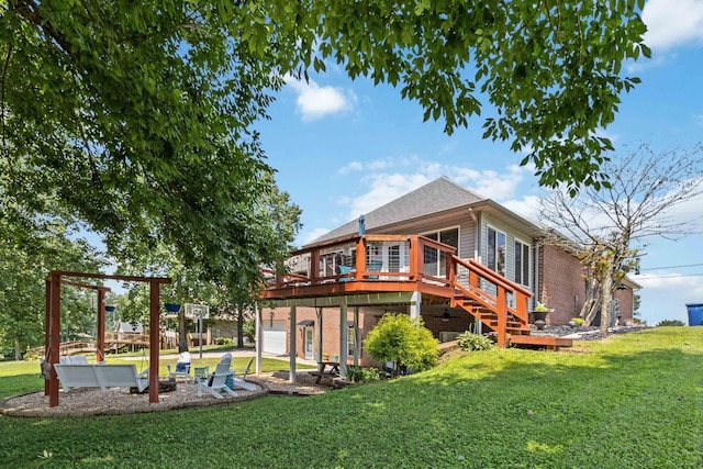 rear view of property featuring a garage, a deck, and a yard