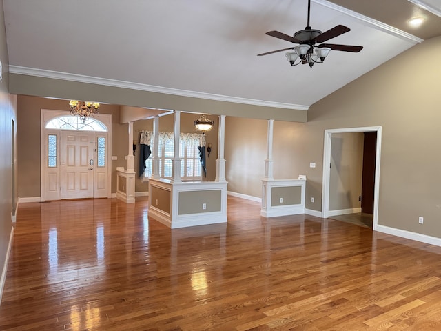 unfurnished living room with decorative columns, hardwood / wood-style floors, ceiling fan with notable chandelier, and lofted ceiling