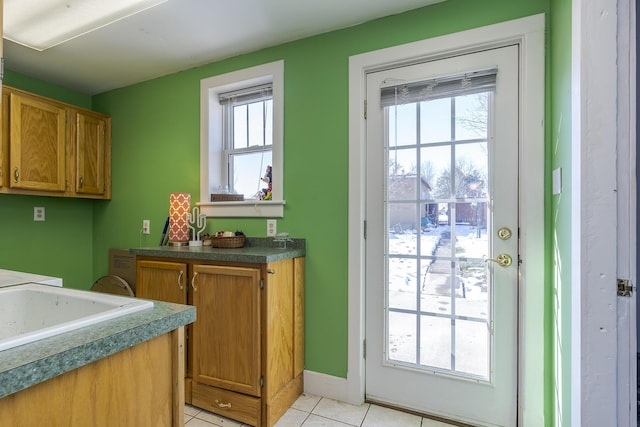 doorway to outside with light tile patterned flooring