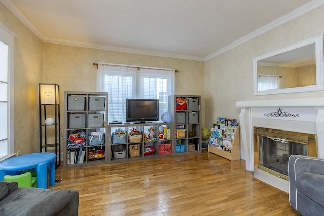 recreation room featuring ornamental molding and hardwood / wood-style flooring