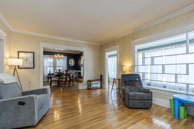 living room with hardwood / wood-style floors, crown molding, and an inviting chandelier