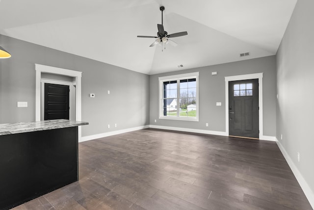 unfurnished living room featuring vaulted ceiling, ceiling fan, and dark wood-type flooring