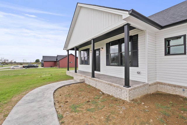 property entrance with covered porch and a yard