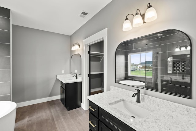 bathroom with vanity, hardwood / wood-style flooring, and independent shower and bath