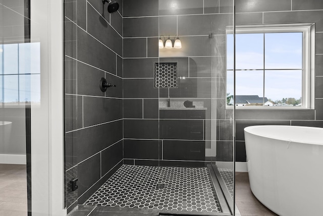 bathroom featuring shower with separate bathtub