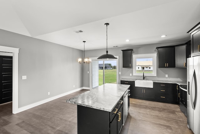 kitchen featuring stainless steel appliances, sink, a notable chandelier, a center island, and hanging light fixtures