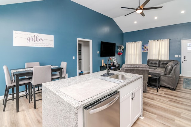 kitchen featuring dishwasher, lofted ceiling, white cabinetry, sink, and a kitchen island with sink