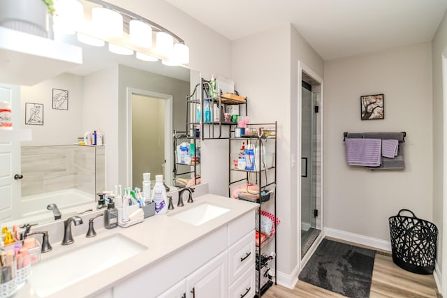 bathroom with hardwood / wood-style floors, vanity, and separate shower and tub