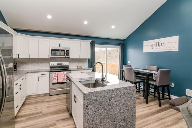 kitchen featuring sink, white cabinetry, a center island with sink, and appliances with stainless steel finishes